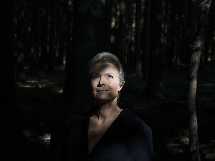 Forfatterportræt Helle Helle: står i lysningen i en skov
